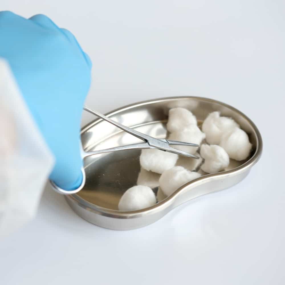 Scissors and organic cotton balls in silver tin